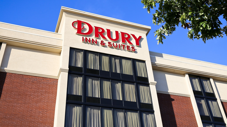 The exterior of a Drury Inn & Suites with red lettering on side of hotel.
