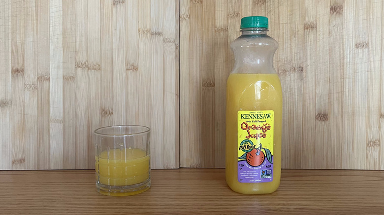 A bottle and glass of Kennesaw orange juice