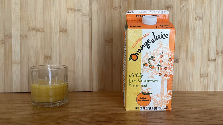 A carton and glass of Trader Joe's orange juice from concentrate