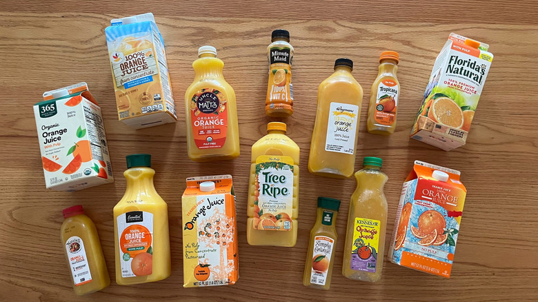 An array of orange juices on a wood background