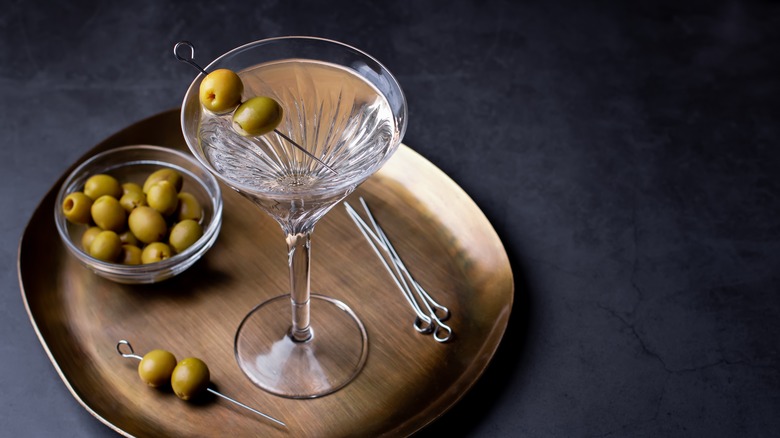 A dirty martini with olives on a plate.