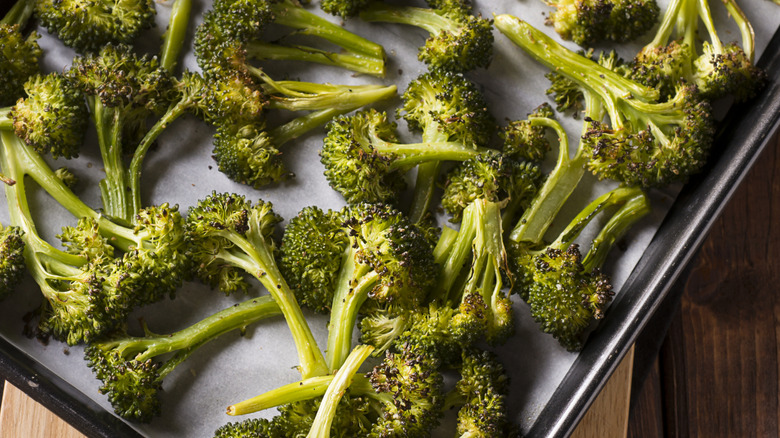 A sheet pan covered with roasted broccoli