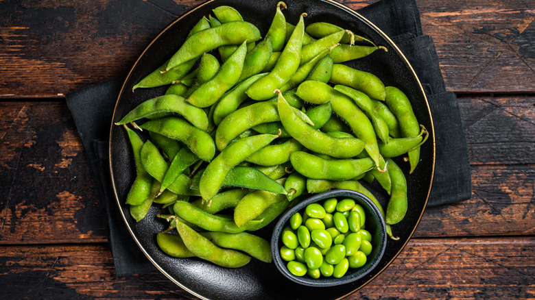 A bowl filled with shelled and unshelled edamame beans
