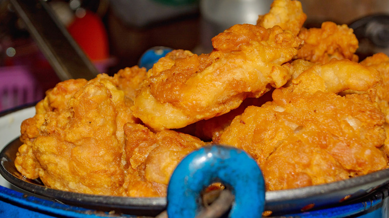 fried chicken in colander inside blue cooking pot