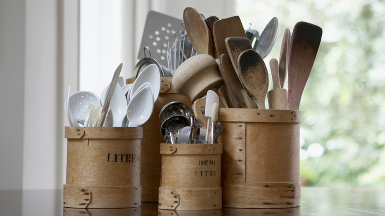 A myriad of kitchen tools and utensils in rustic containers