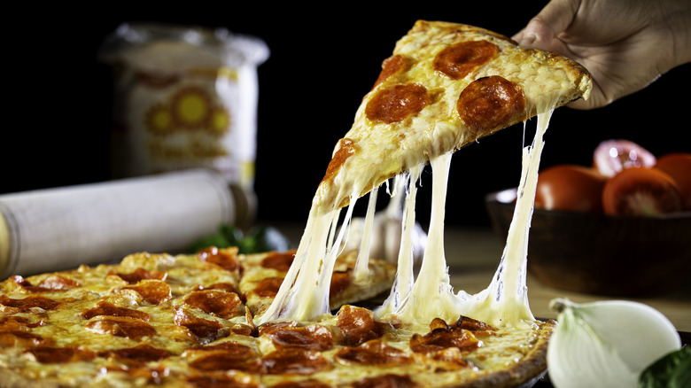 Hand pulling pizza from tray