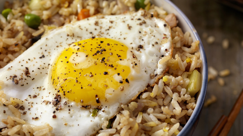 A bowl of rice with an egg on it.