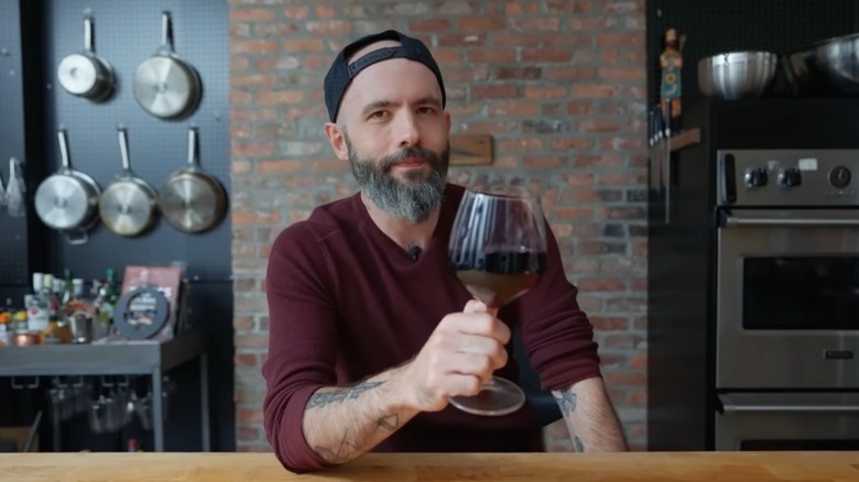 Andrew "Babish" Rea holding a glass of Gatorwine.