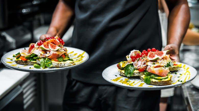 Person carrying two plates of food