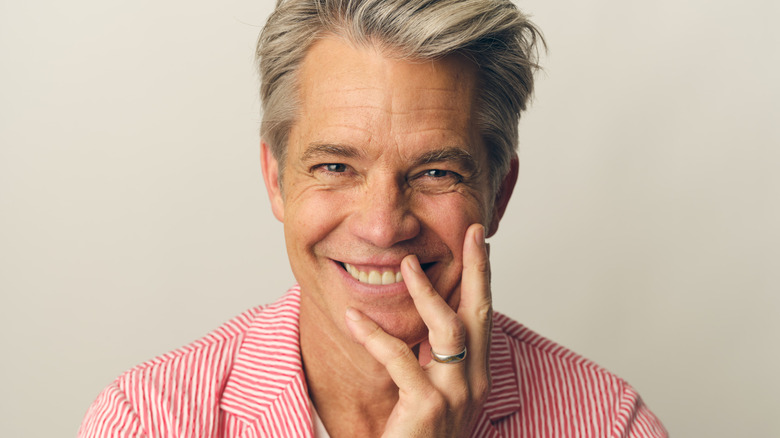 Timothy Olyphant smiles for a portrait in a striped red suit