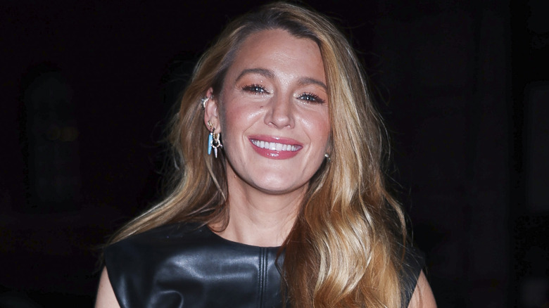 Blake Lively smiles in a black leather outfit at an event
