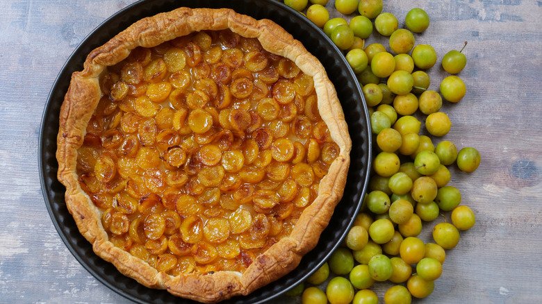 A delicious mirabelle plum pie, surrounded by mirabelles