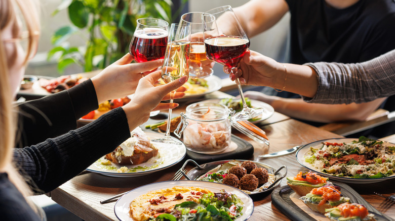 People toasting with wine and beer at a restaurant table