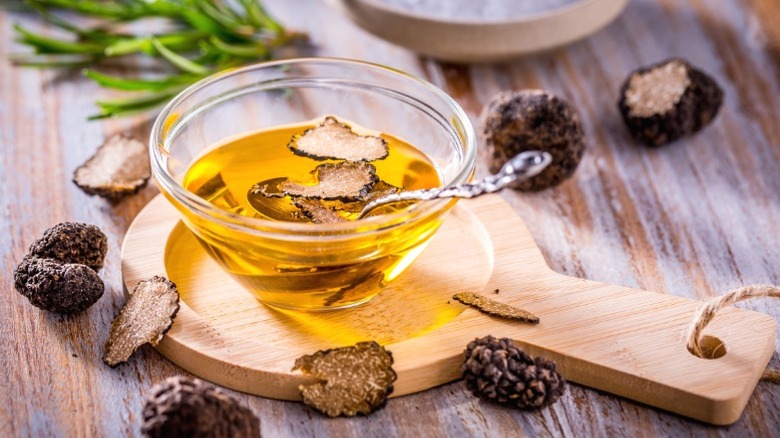 A small bowl of truffle oil on a wooden board.