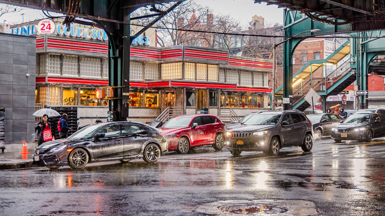 Cars driving on a rainy day in front of a diner in Queens, New York