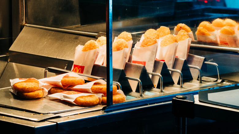 Several McDonald's hash browns laying under a heat lamp