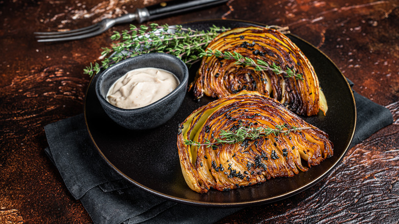 Grilled cabbage steaks on plate with sauce