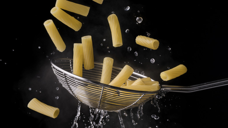 Spider strainer draining water from rigatoni