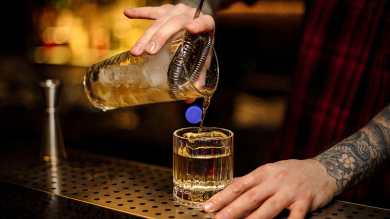 Bartender making a rusty nail cocktail