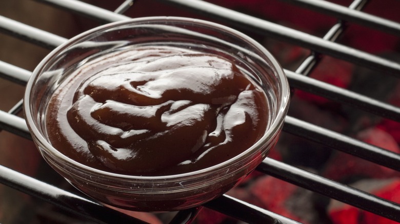 Bowl of BBQ sauce on grill grates
