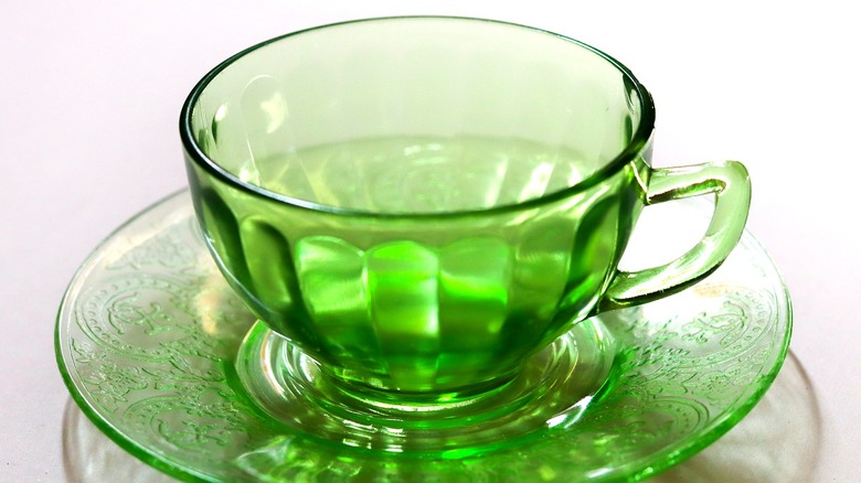 A green uranium glass teacup on display in daylight