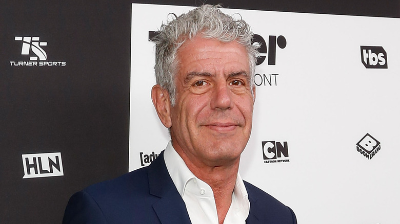 Anthony Bourdain smiling in blue suit jacket