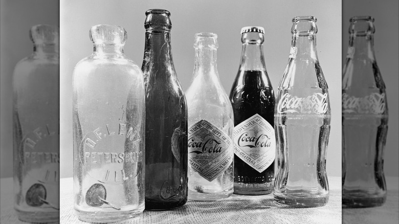 Black and white photo of various vintage Coke bottles