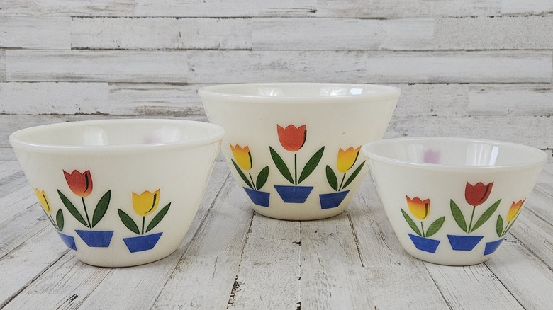 Three Fire-King Tulip mixing bowls on a white background.