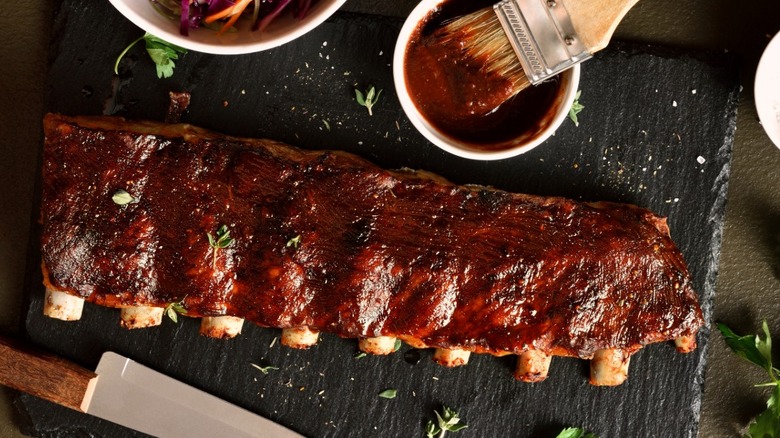ribs on cutting board with barbecue sauce and coleslaw