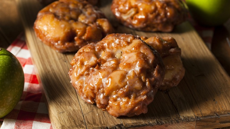 Glazed apple fritters on wood board