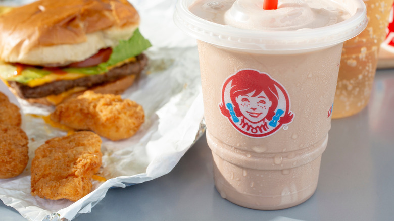 A Wendy's Frosty beside chicken nuggets and a burger.