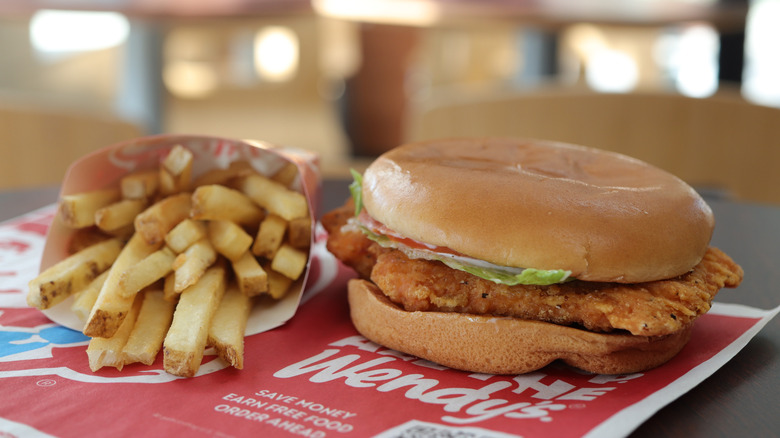 An order of fries beside a crispy chicken sandwich from Wendy's