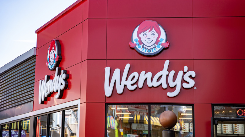 The red and black exterior of a Wendy's location during the day