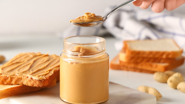 A spoon gathering peanut butter.