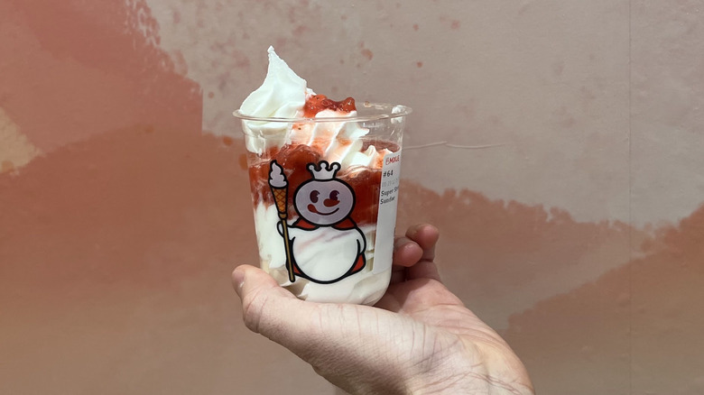 Hand holding a strawberry sundae from Mixue