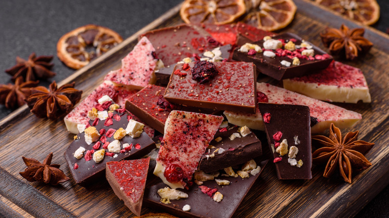 Wooden tray of artisan chocolate bars garnished with spices and dried orange slices