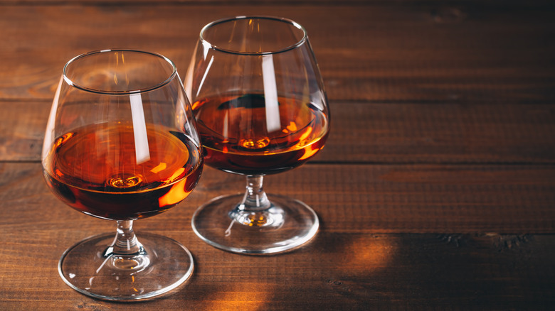 Two glasses of cognac on dark wood table