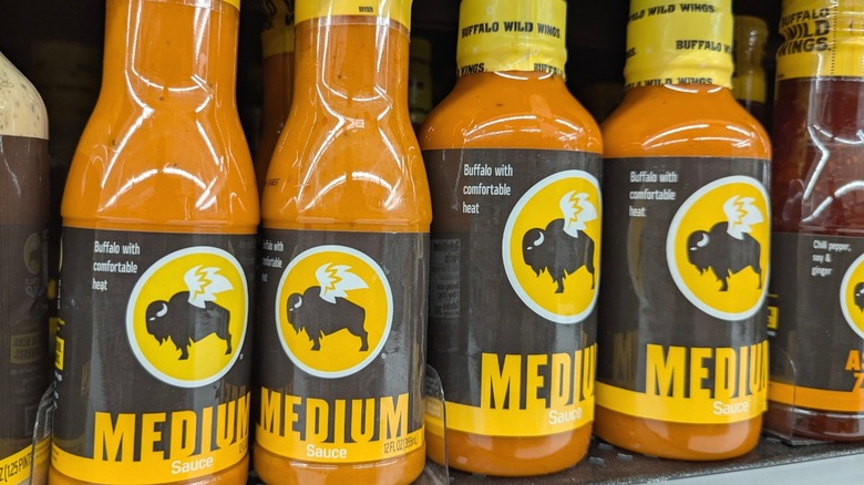 Bottles of Buffalo Wild Wings sauce on a supermarket shelf.