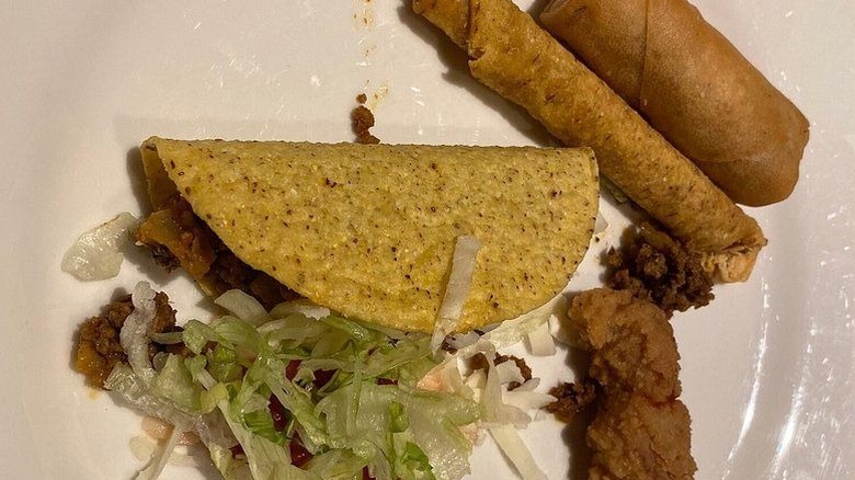 Taco, egg roll, tacquiro, and chicken strip on plate from Circus Buffet