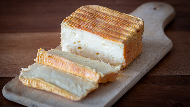 sliced limburger cheese on a wooden board