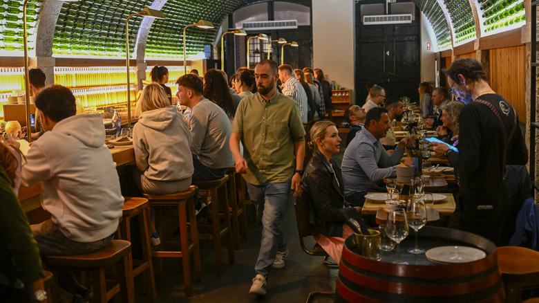 A busy restaurant that features both tables and bar seating.