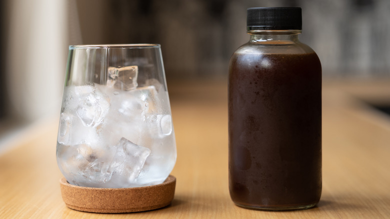 Bottle of cold brew next to glass of ice