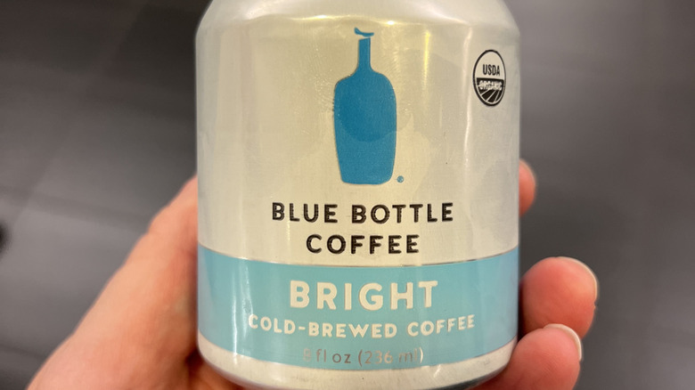 Hand holding small can of Blue Bottle Coffee Cold-Brewed Coffee