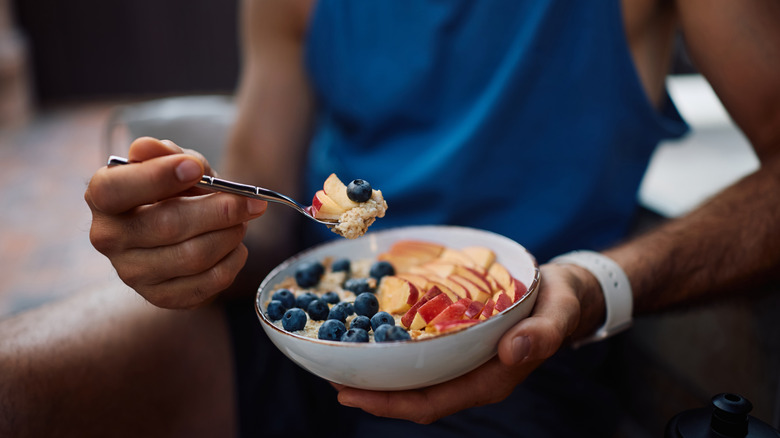 Close up of someone eating fruit-topped porridge