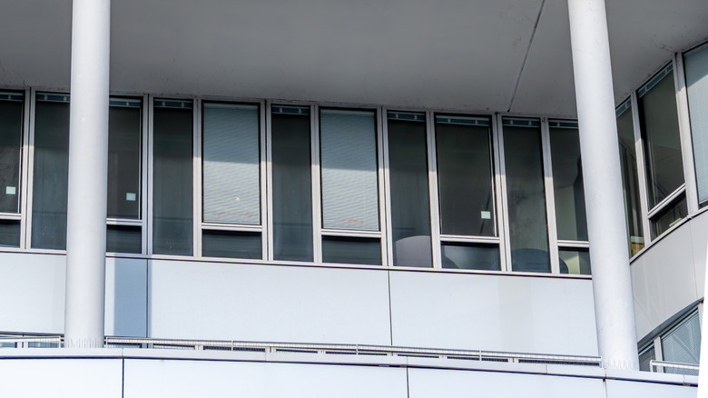 Exterior of Danone headquarters with small brand logo on white building under awning with skylight windows