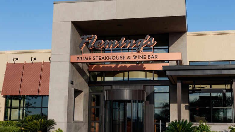 The brown and pink exterior of a Fleming's restaurant.
