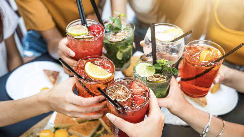 People toasting with assorted colorful cocktails
