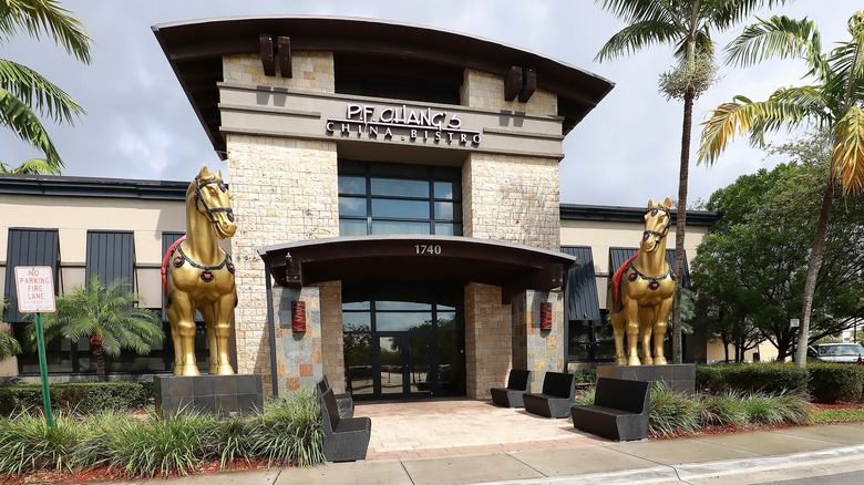 Exterior of a P.F Chang's with two large horse statues by the door