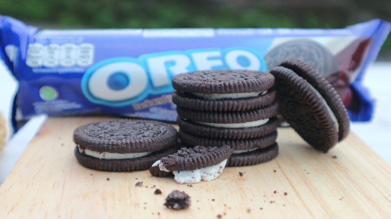 individual Oreos stacked in front of Oreo cookie package