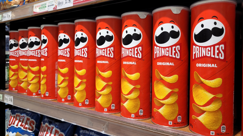 Pringles canisters lining grocery store shelf